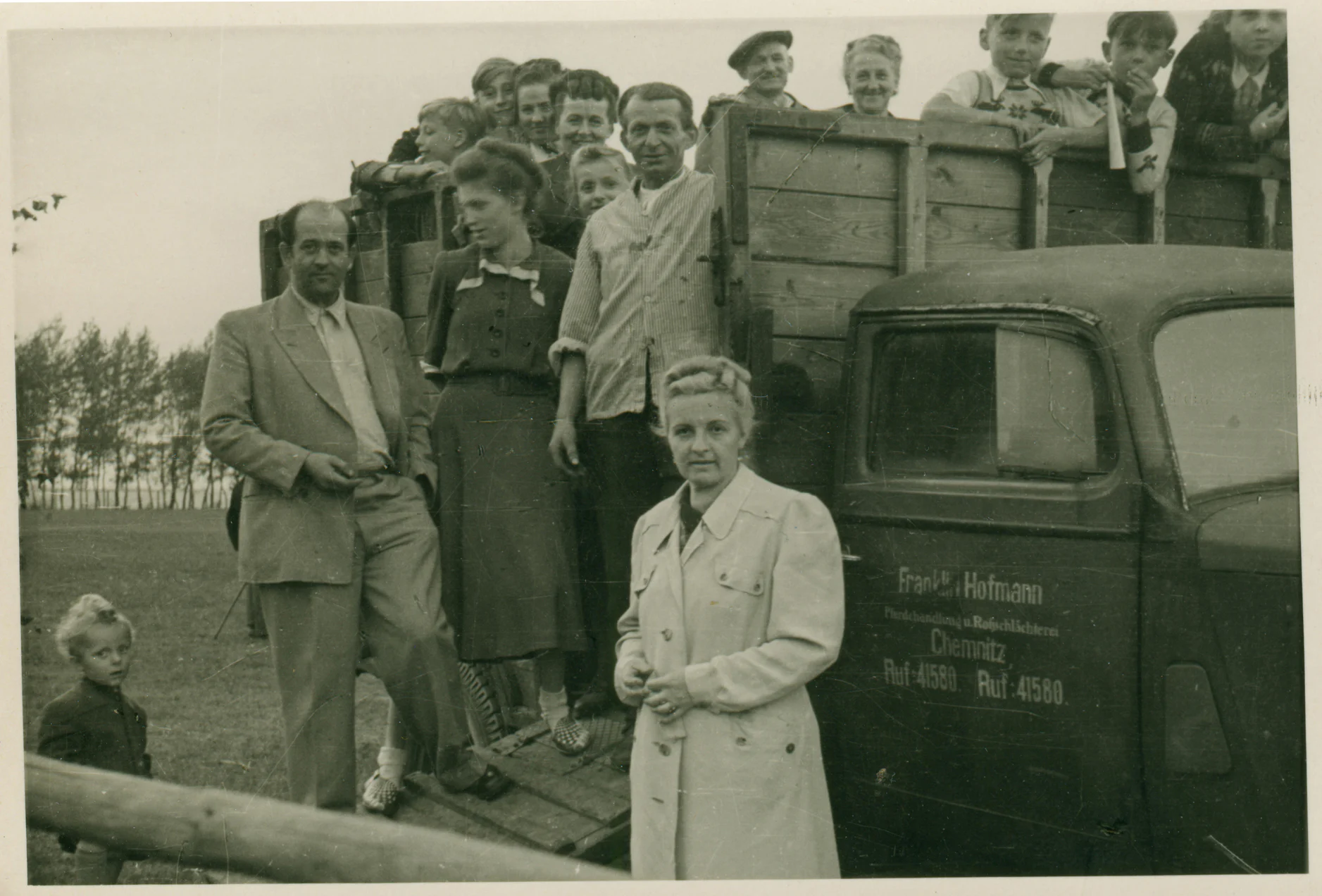 Mitarbeiter und Familie am historischen Lieferwagen