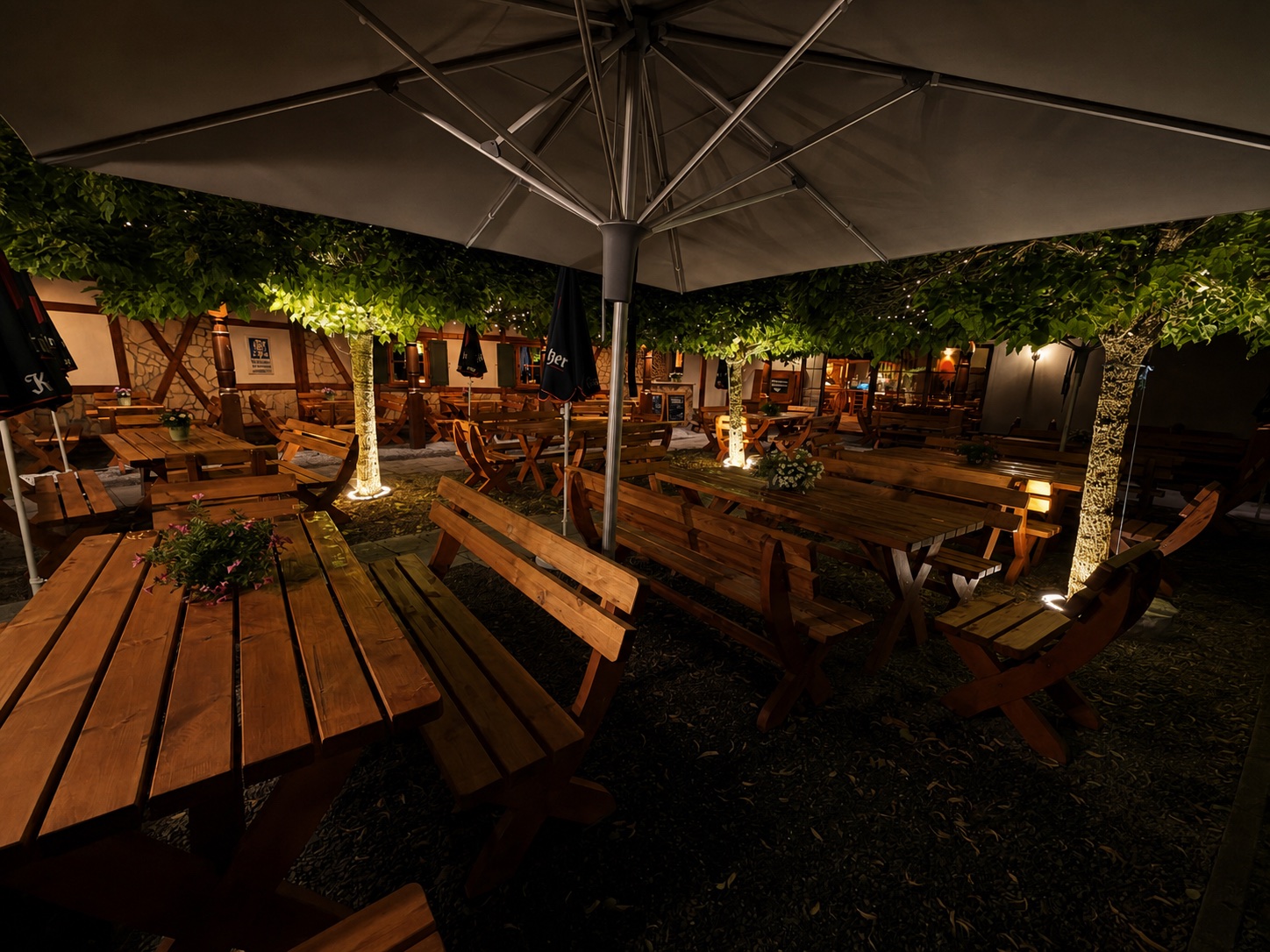 Biergarten mit großen Schirmen am Abend