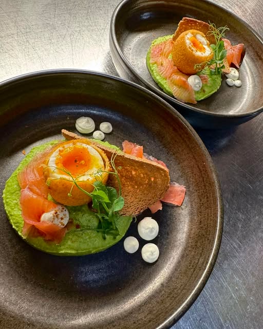 Zwei angerichtete Vorspeisen mit Lachs, Ei und Kräutern